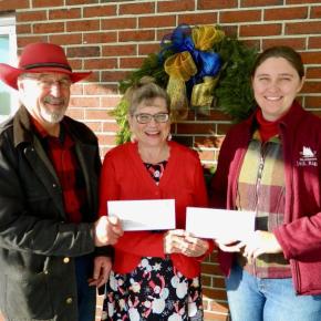 One male and two females pose with two checks