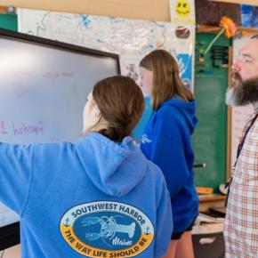 students work at a large electronic writing pad