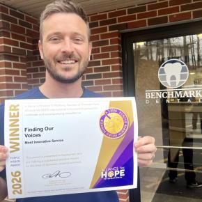 Robert Belanger holds Purple Ribbon Award certificate