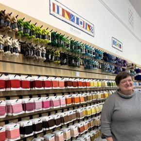 Woman stands along wall of retail items