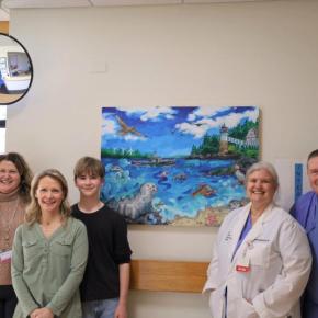 People pose in front of Peaceful Beginnings painting