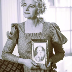 woman in costume holding framed portrait