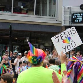 A man holds a sign that reads Jesus loves you