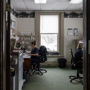 two women reviewing paperwork while sitting at desks