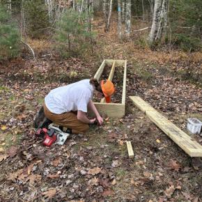 woman builds wooden footpath