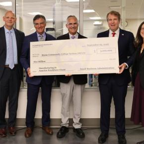 six adults pose with presentation check