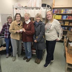 five women pose with check