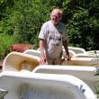 Bill Coughlin, a.k.a. "Mr. Tubs," with some of the dozens of cast iron tubs he keeps outside his Belmont workshop. (Photo by Ethan Andrews)