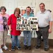 From left, Retta Goughnour, BillieJo Stewart, Jared Stewart, and John Paul Carr pose with a poster showcasing memories from 1999 during the 25th anniversary celebration of Bank of America’s Belfast Support Services. (Photo courtesy Bank of America)