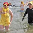 Nicole Larrabee in yellow bathing suit is a Finding Our Voices board member, and Mary Kamradt right behind her is the nonprofit’s chief of staff. They were two of dozens wading into frigid water at Rockport Harbor with Wicked Nippy Dippahs. (Photo by Jane Kurko)