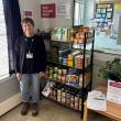 Sharon McVaugh, family peer support partner at Maine Behavioral Health in Rockland, stands with the new Help Yourself Shelf.  McVaugh is also the site champion for MaineHealth Pen Bay Hospital’s newest shelf. (Photo courtesy MaineHealth)