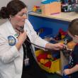 a medical student uses a stethoscope on a young boy.
