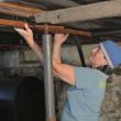 Wrapping pipes to insulate, improves efficiency for the older housing stock. (Photo courtesy Midcoast Habitat for Humanity)