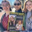 L-r: Lizzie Dunn, Melanie C., and Eva Harvie of Morning Glory Natural Foods in Brunswick on the sidewalk where the Finding Our Voices “Breaking the Silence of Domestic Abuse” march will take place the morning of Saturday, May 10. Folks are encouraged to wear yellow and bring signs expressing what they want the public to know about domestic abuse. The Finding Our Voices poster in the photo is part of a public awareness campaign featuring the photo portraits and quotes of 50 Maine survivors,  in business wind
