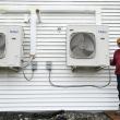 a man standing next to heat pumps