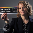 regina rooney holds a bumper sticker that reads no excuse for partner abuse