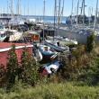 Vehicle on its side at the foreground of a boatyard