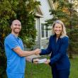 Dentist and community healthcare president pose with check