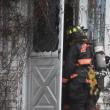 firefighter looks into the entryway of a house