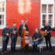 Lunasa in front of red brick building