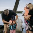 Adults helping children into life jackets
