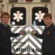 Teenagers hold the handles of an ambulance