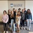 teen group photo in front of a UMaine logo