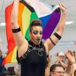 Person raising rainbow flag above the head