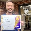 Robert Belanger holds Purple Ribbon Award certificate