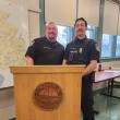 two men in uniform stand at lectern