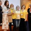 six adults pose with award