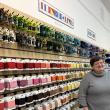Woman stands along wall of retail items