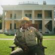 man in uniform in front of house