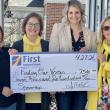 four women hold presentation check