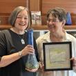 two women pose with examples of their art