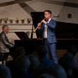 male in blue suit plays wind instrument