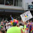 A man holds a sign that reads Jesus loves you