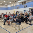 People filter into the auditorium, slowly filling seats. (photo by Erica Thoms)