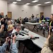 journalists crowd around an election official 