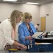 election officials look at pieces of paper.