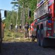 People with hard hats walk toward fire trucks