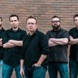 five men wearing black shirts and denim pants