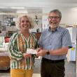 J.P. Fecteau of the West Bay Rotary Satellite Club presents a $1,694 donation to Tia Anderson, Executive Director of Midcoast Habitat for Humanity, inside Midcoast Habitat’s new ReStore location in Rockport. The donation will support a Habitat home in Thomaston.