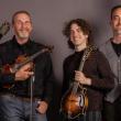 four people pose with instruments
