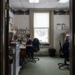 two women reviewing paperwork while sitting at desks