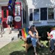shopper enters store while two others sit in Adirondack chairs
