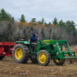 green tractor pulling red trailer