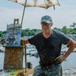 man poses with his painting