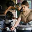two women handling pots
