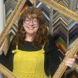 woman poses through empty picture frame